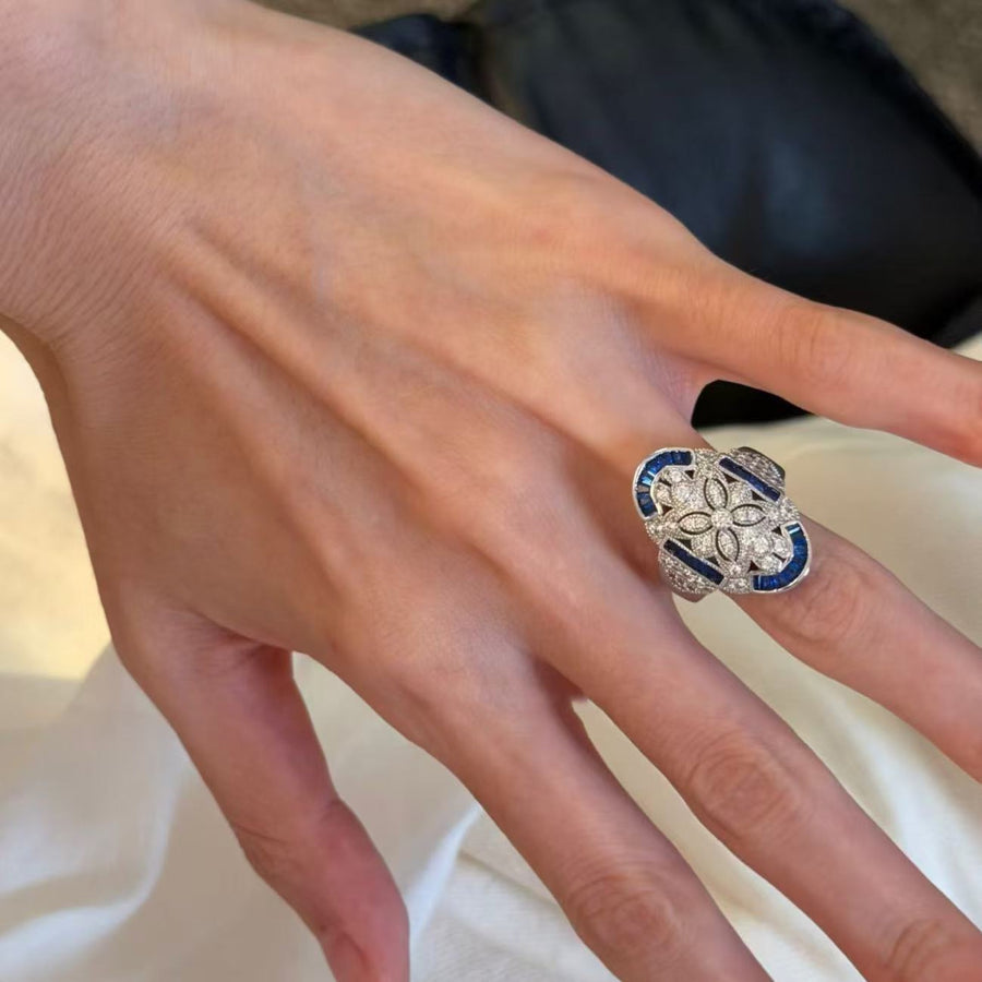 Blue and silver-tone statement ring worn on the index finger