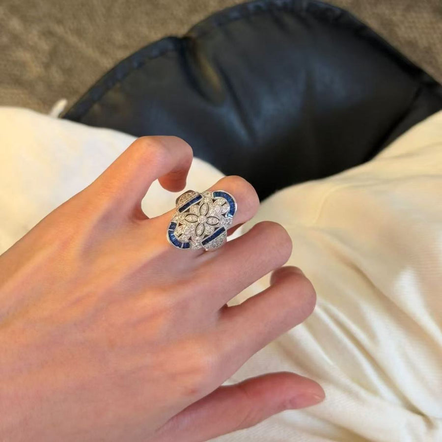 Blue and silver-tone statement ring worn on the index finger