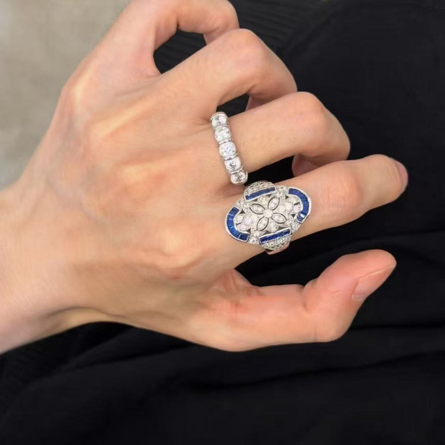 Blue and silver-tone statement ring worn on the index finger