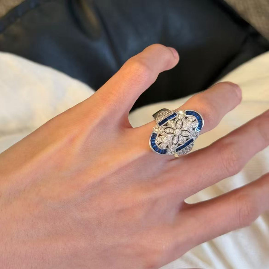 Blue and silver-tone statement ring worn on the index finger